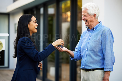 Buy stock photo Cropped shot of an attractive young real estate agent handing the keys of a newly purchased home to her male client outside