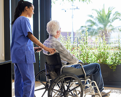 Buy stock photo Shot of a nurse helping her patient in a wheelchair
