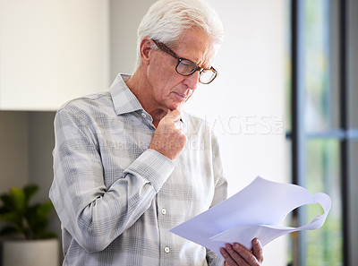 Buy stock photo Shot of a mature man reading paperwork