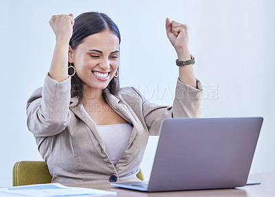 Buy stock photo Shot of a young businesswoman cheering while working on a laptop in an office