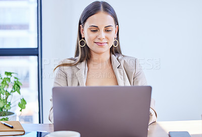 Buy stock photo Shot of a young businesswoman working on a laptop in an office