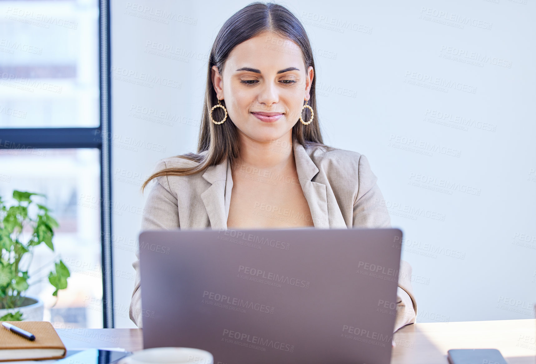 Buy stock photo Shot of a young businesswoman working on a laptop in an office