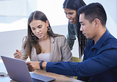 Buy stock photo Shot of a group of businesspeople working together on a laptop in an office