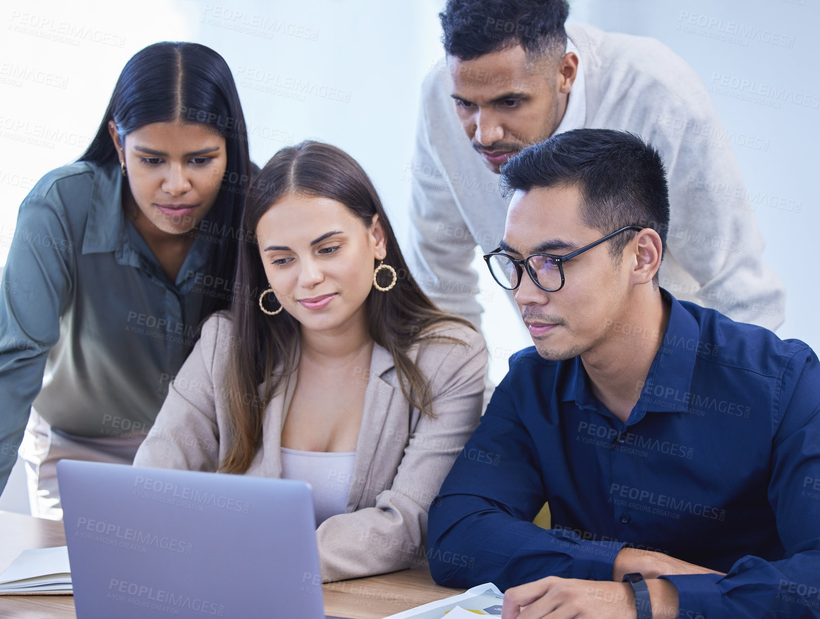 Buy stock photo Shot of a group of businesspeople working together on a laptop in an office