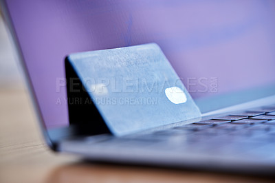 Buy stock photo Shot of a credit card and laptop on a desk in an empty office during the day