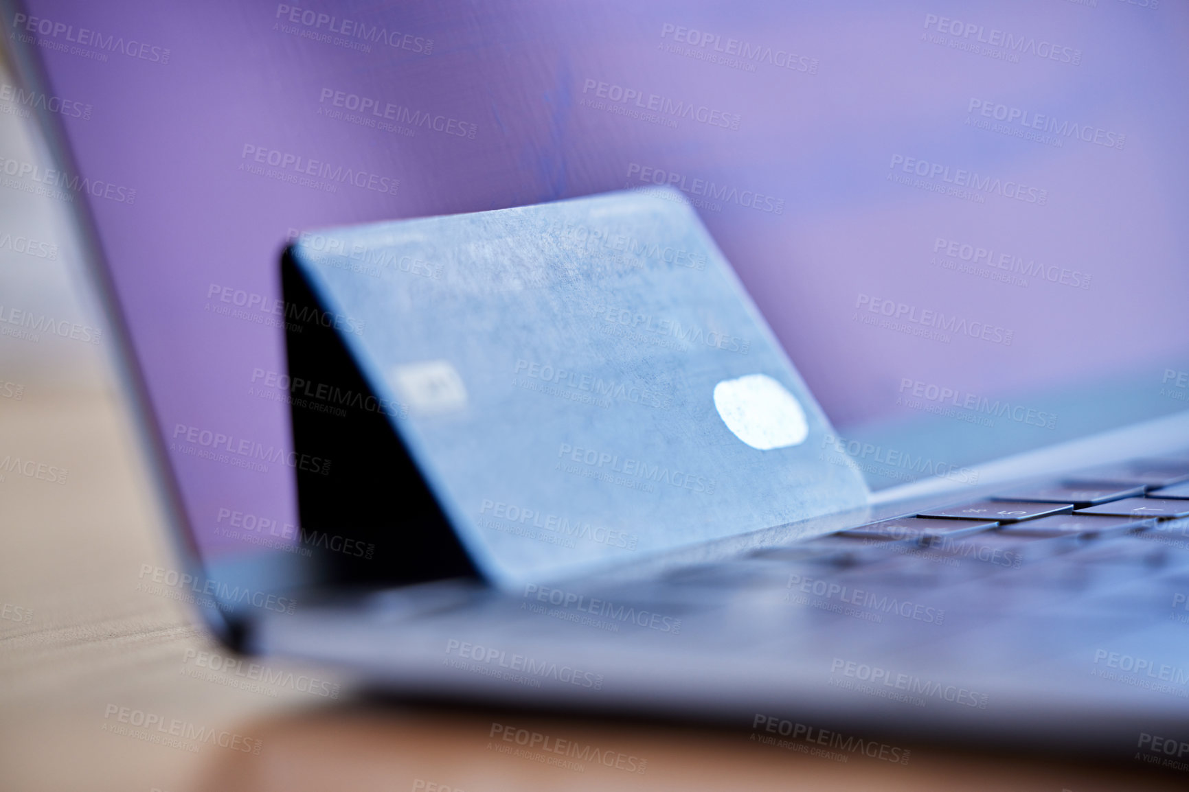 Buy stock photo Shot of a credit card and laptop on a desk in an empty office during the day