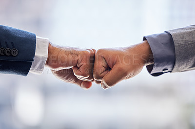 Buy stock photo Cropped shot of two unrecognizable businesspeople standing together and giving each other a fist bump in the office
