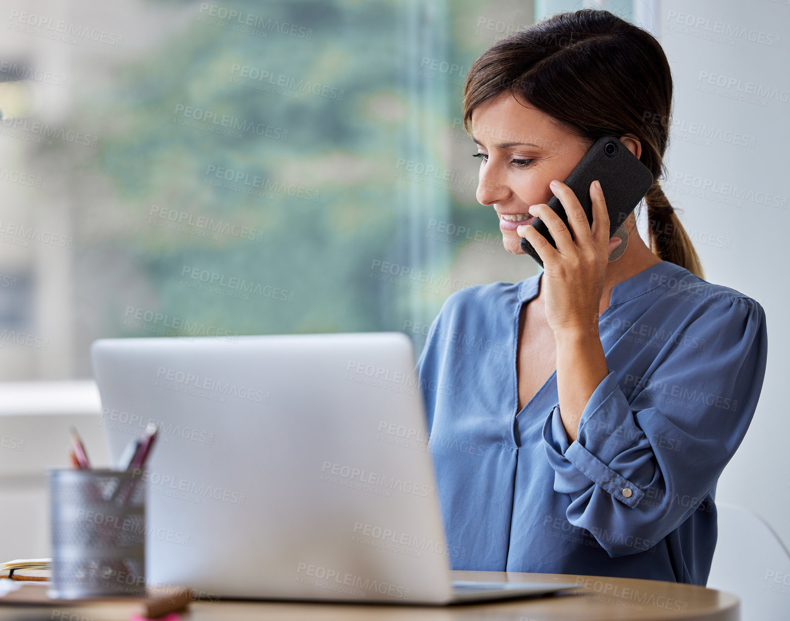 Buy stock photo Shot of a young businesswoman using her smartphone to make a phone call