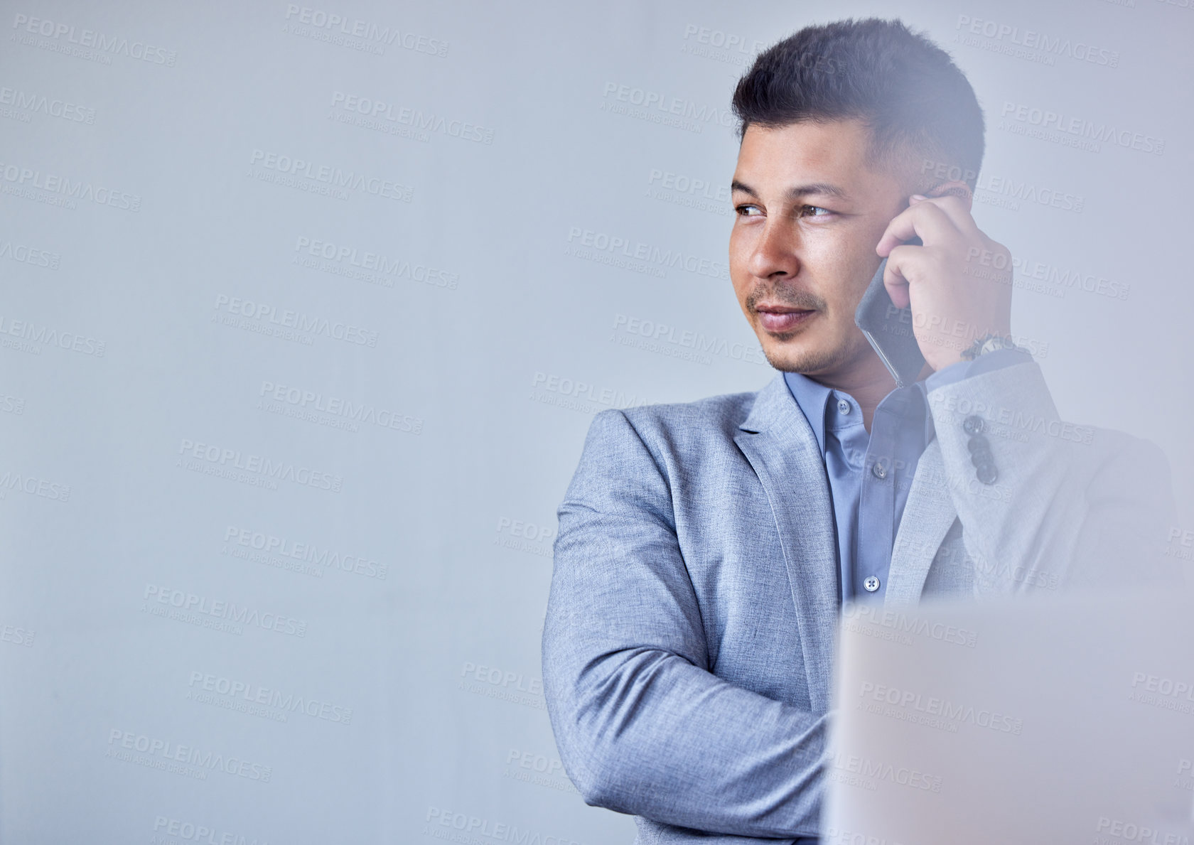 Buy stock photo Shot of a young businessman using his smartphone to make a phone call