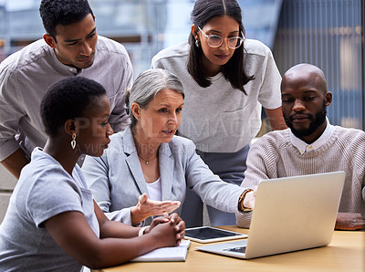 Buy stock photo Shot of a group of professional coworkers using a laptop together at work