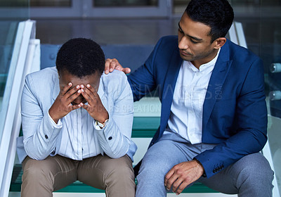 Buy stock photo Shot of a young man comforting his colleague at work