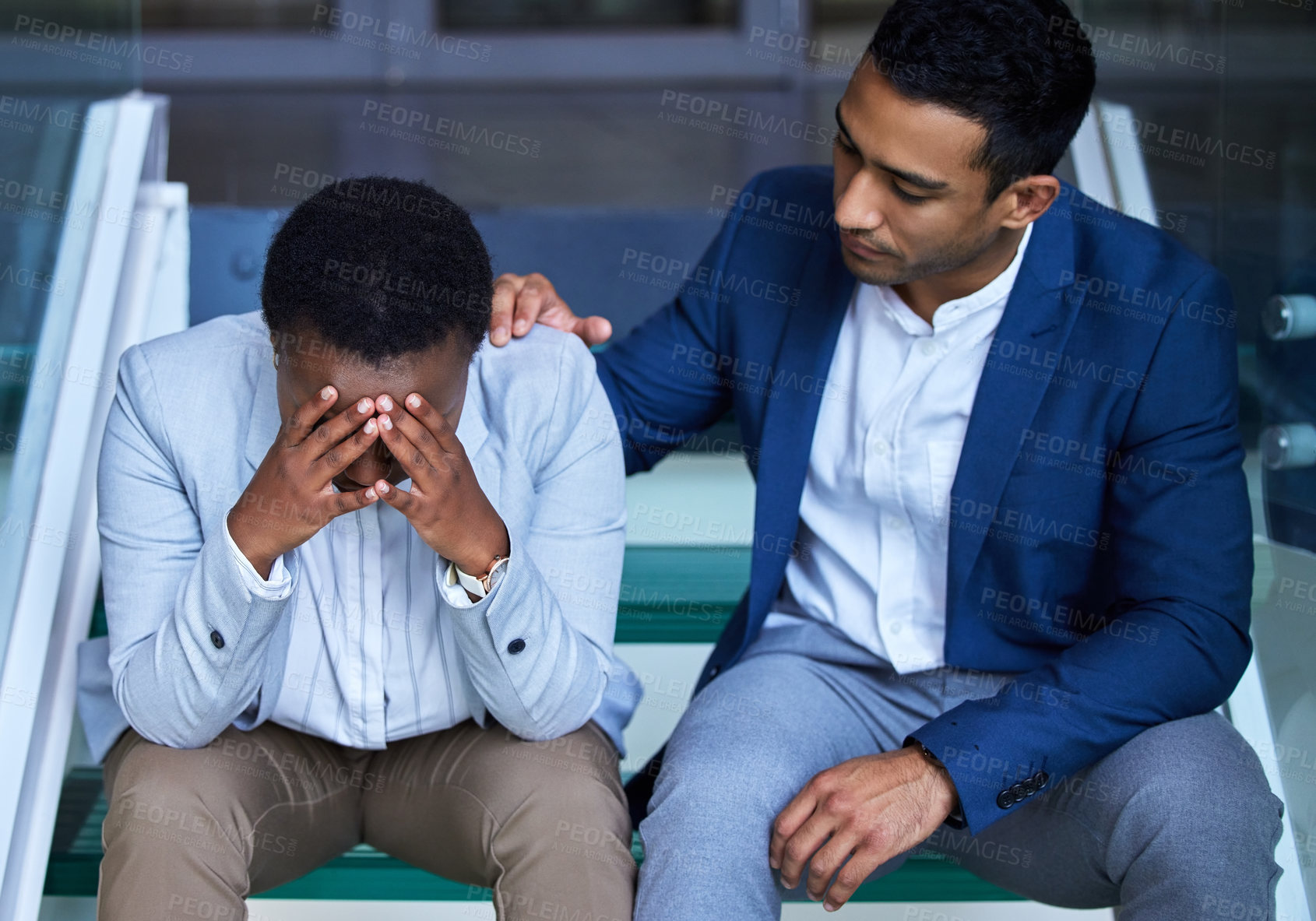 Buy stock photo Shot of a young man comforting his colleague at work