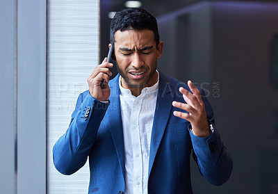 Buy stock photo Shot of a young man using his phone at work