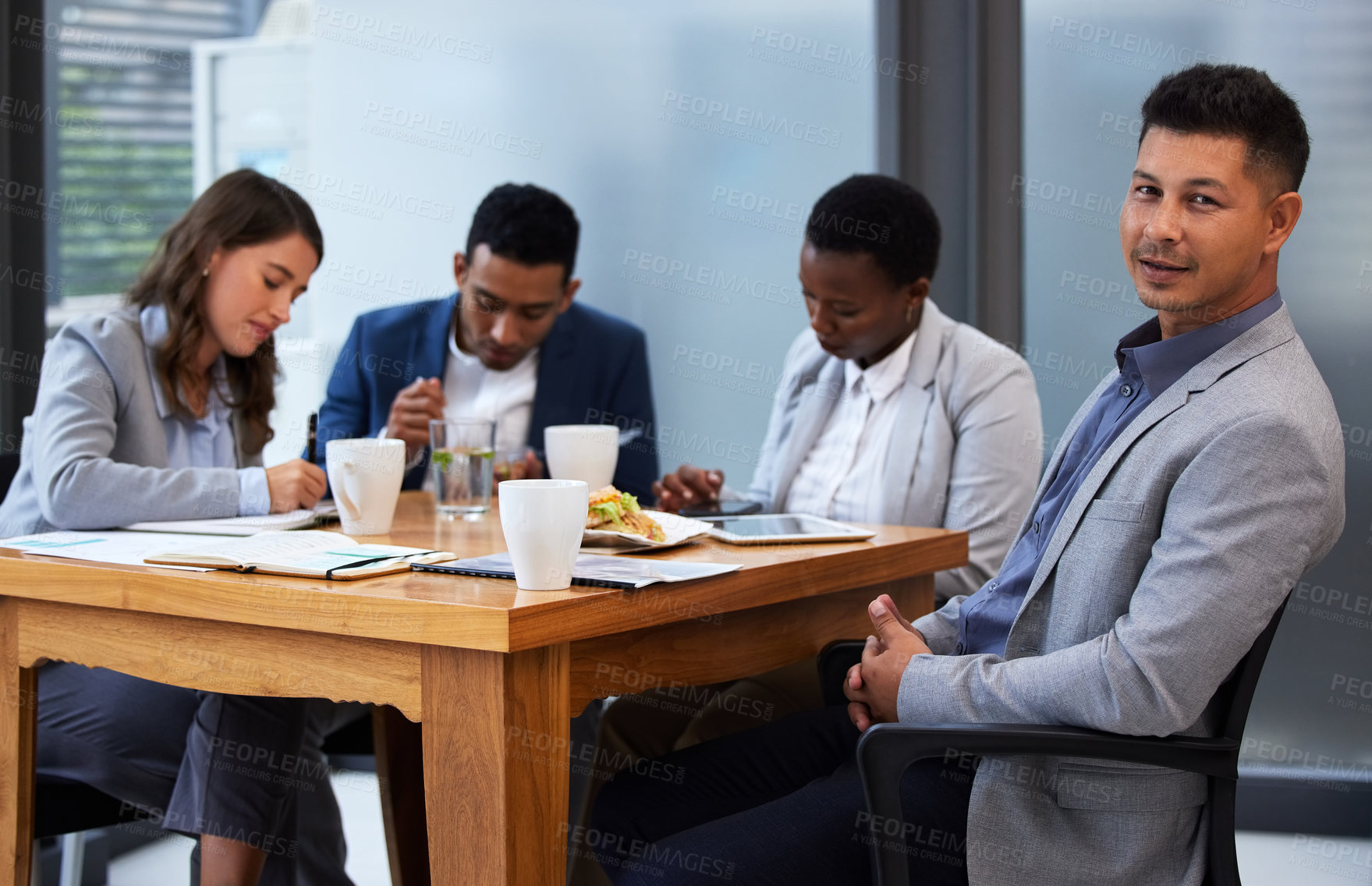 Buy stock photo Shot of a group of colleagues having a meeting and breakfast in a modern office