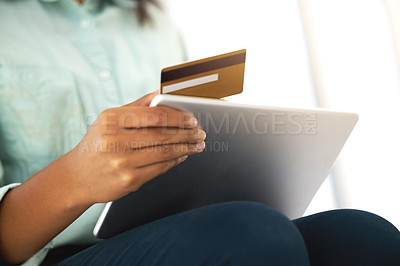 Buy stock photo Cropped shot of an unrecognizable person using a credit card and a digital tablet to shop online at home