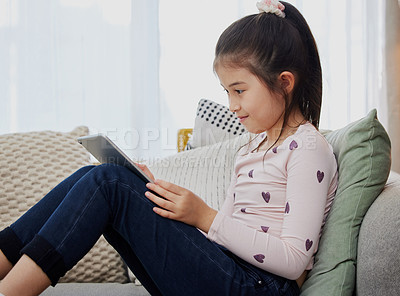 Buy stock photo Child, tablet and online in home for e learning, reading and streaming video with education app. Girl, kid and happy on couch for weekend, technology and internet for games and social media 