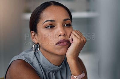 Buy stock photo Shot of an attractive young businesswoman sitting alone in the office in the evening and looking bored