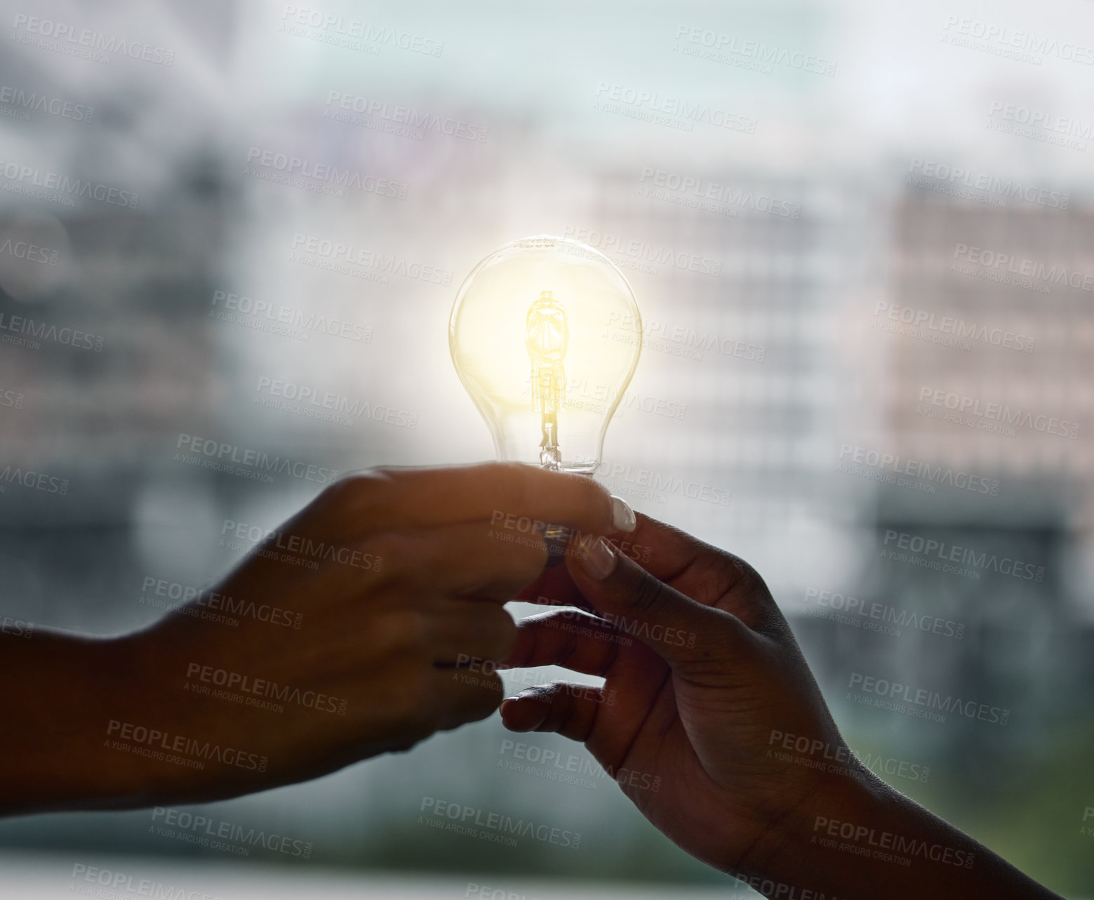 Buy stock photo Cropped shot of two unrecognizbale businesspeople standing together and holding a lightbulb in the office