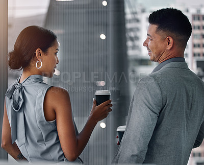 Buy stock photo Shot of two businesspeople standing together in the office and having a discussion in the evening