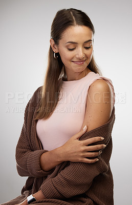 Buy stock photo Shot of a young woman standing alone in the studio after getting vaccinated
