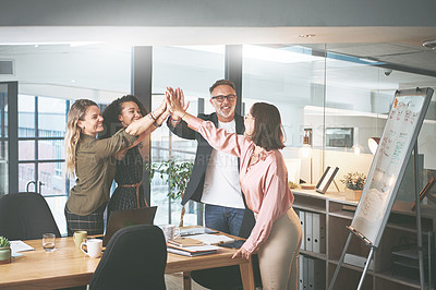 Buy stock photo Shot of a diverse group of businesspeople giving each other a high five during a meeting in the office