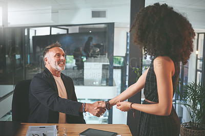 Buy stock photo Shot of two businesspeople shaking hands during a meeting in the office