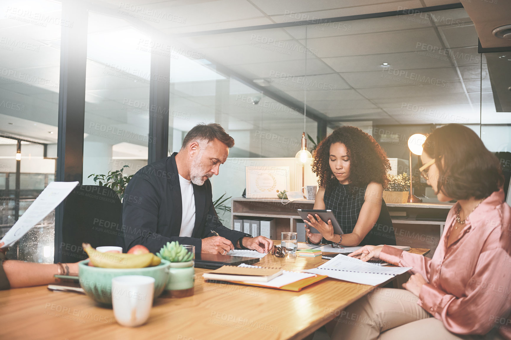 Buy stock photo Shot of a diverse group of businesspeople sitting together in the office and planning during a meeting