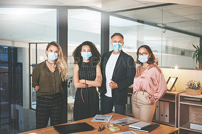 Buy stock photo Shot of a diverse group of businesspeople standing together in the office and wearing face masks