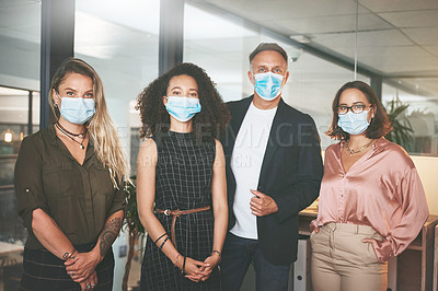 Buy stock photo Shot of a diverse group of businesspeople standing together in the office and wearing face masks