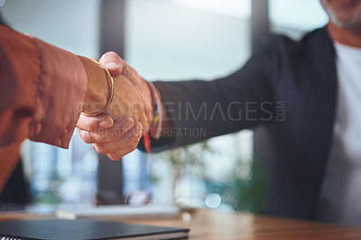 Buy stock photo Cropped shot of two unrecognizable businesspeople shaking hands during a meeting in the office