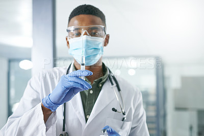 Buy stock photo Shot of a young doctor holding a syringe in an office