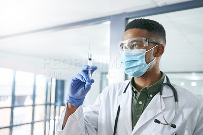 Buy stock photo Shot of a young doctor holding a syringe in an office