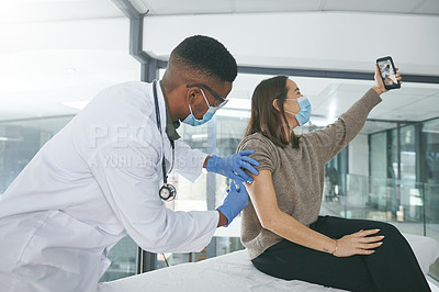 Buy stock photo Shot of a young doctor giving a patient an injection while she takes a selfie in an office