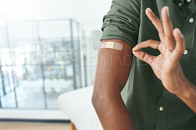 Buy stock photo Shot of an unrecognizable person's arm with a band-aid while they show an okay sign