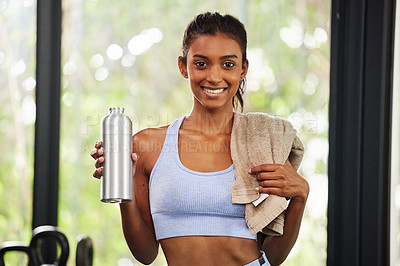 Buy stock photo Shot of a beautiful young woman holding her water bottle and towel at the gym