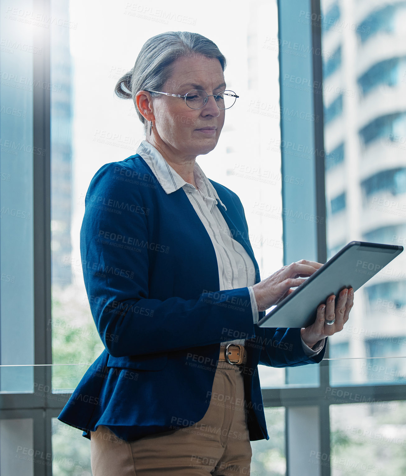 Buy stock photo Shot of a mature businesswoman using a digital tablet at work