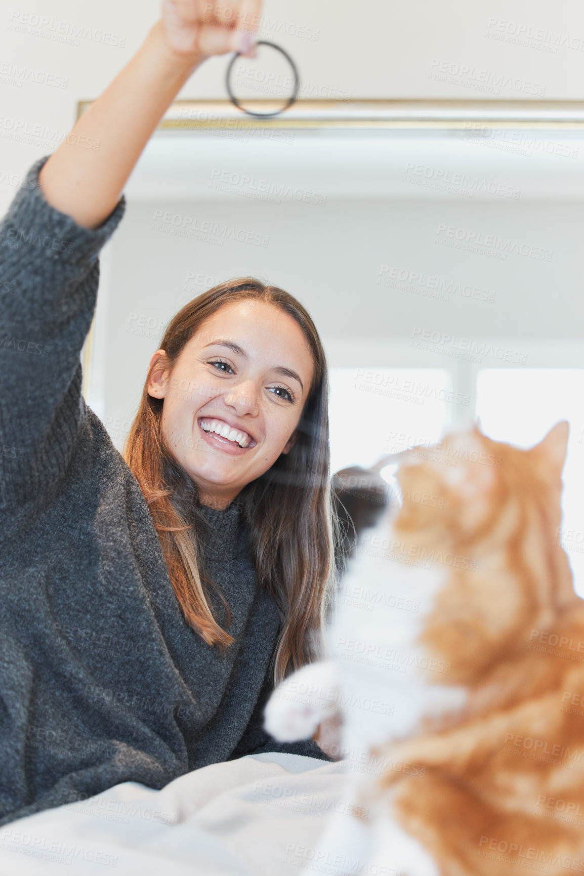 Buy stock photo Shot of a young woman playing with her cat at home