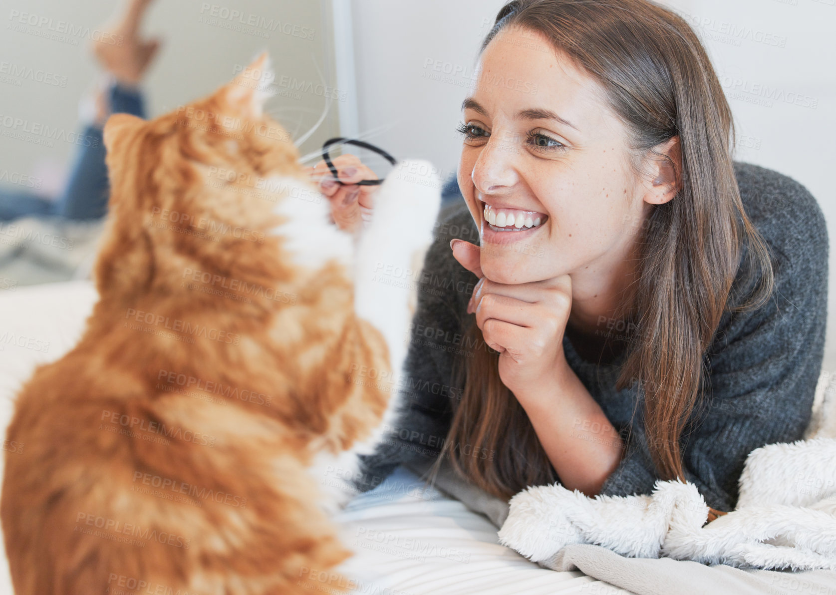 Buy stock photo Love, smile and playful woman with cat in bedroom of home for bonding or fun as pet owner. Bed, happy or toys and person playing with adorable kitten in apartment for morning or winter relaxation
