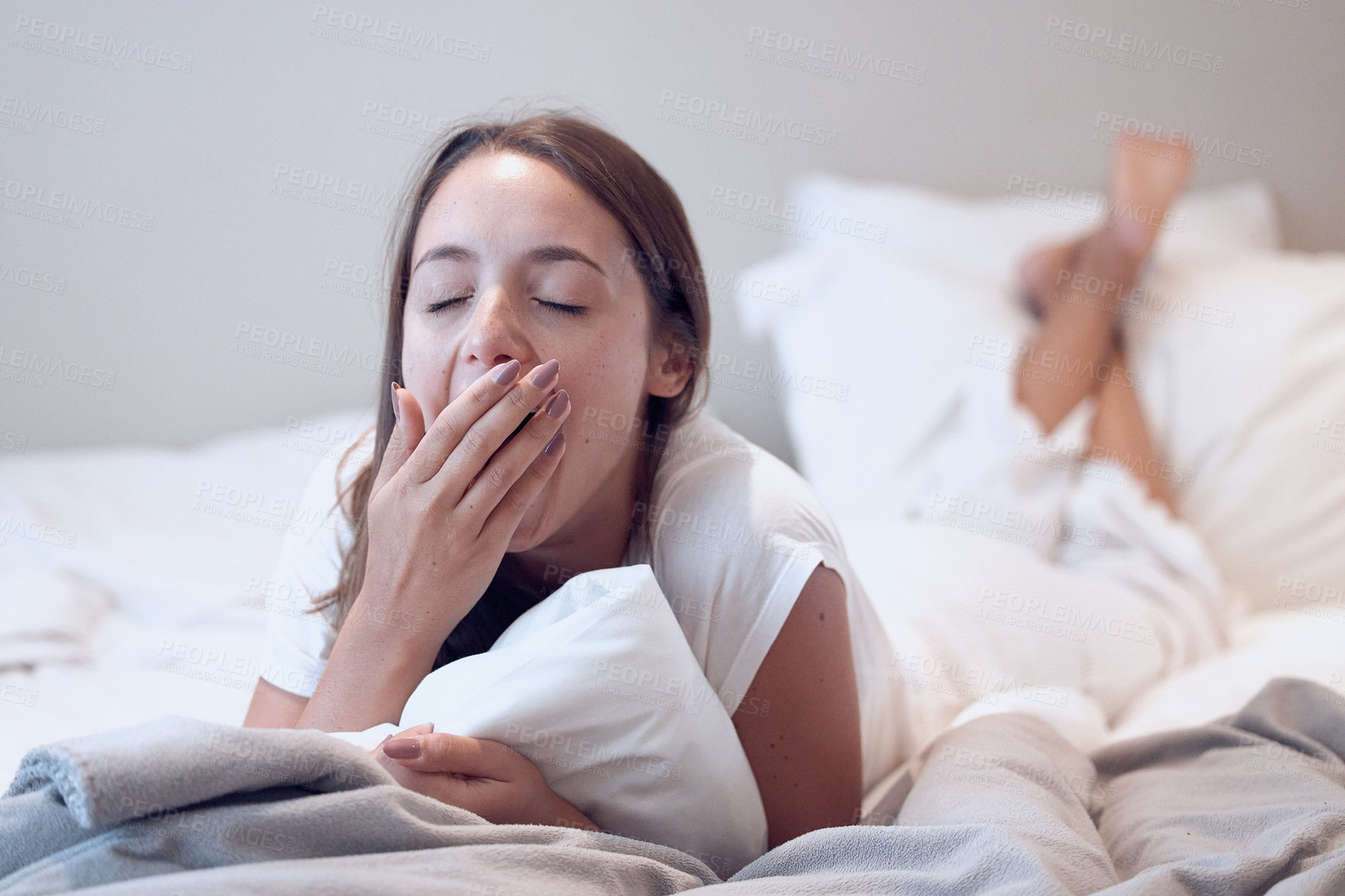 Buy stock photo Yawning, sleepy and woman lying on bed for low energy, exhausted or morning insomnia in bedroom. Fatigue, student or female person cover mouth for tired, bored or  burnout from university in home