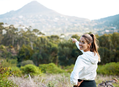 Buy stock photo Portrait of a young woman pointing to a scenic view while exercising outdoors