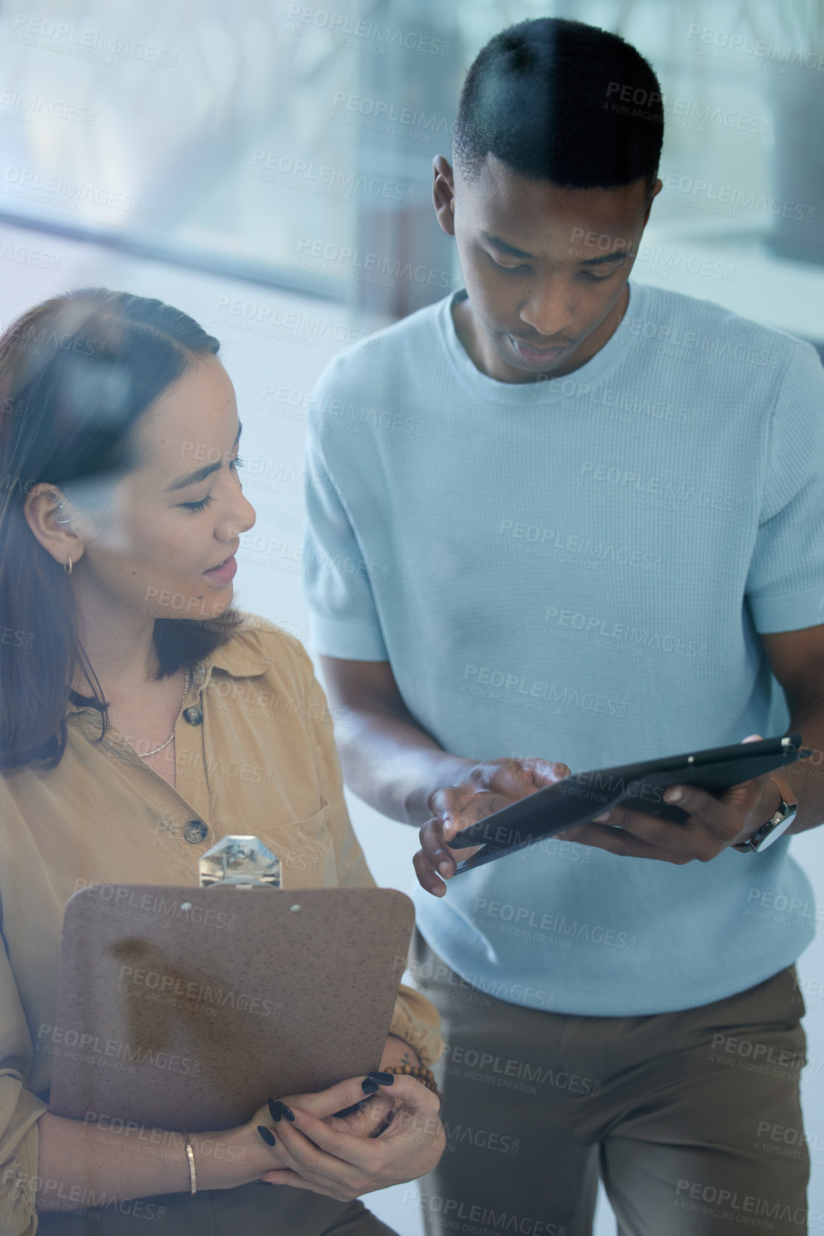 Buy stock photo Shot of two businesspeople using a digital tablet together in an office