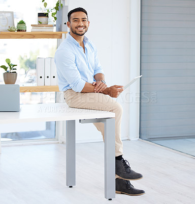 Buy stock photo Shot of a young businessman using a digital tablet at work