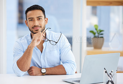 Buy stock photo Shot of a young man using a laptop at work