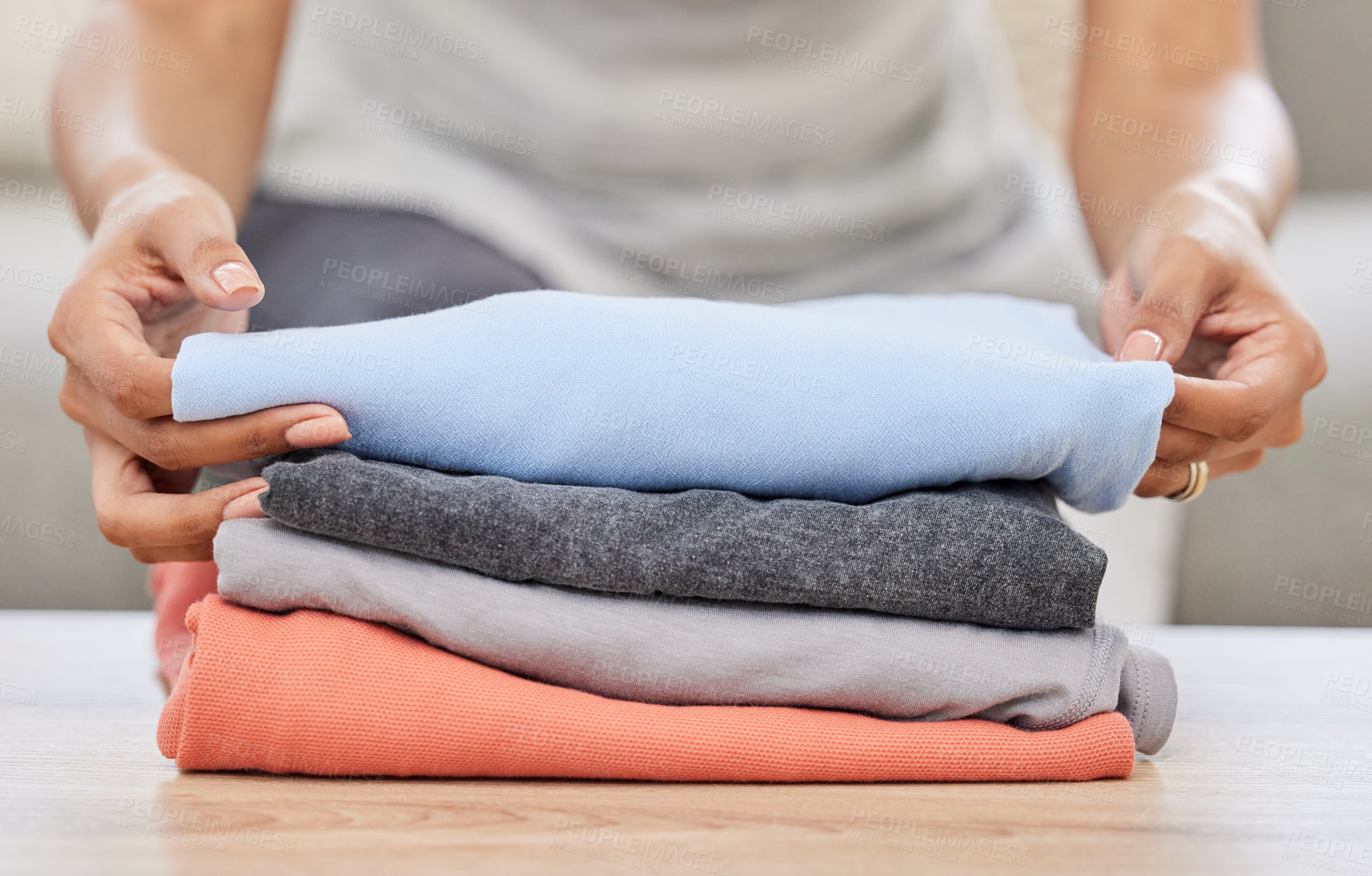 Buy stock photo Woman, hands and laundry with pile on sofa for clean clothing, chores or housekeeping at home. Closeup of female person, cleaner or maid with dry washing or stack for neat and tidy apartment or house