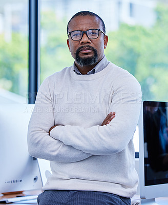 Buy stock photo Portrait of a mature businessman standing with his arms crossed in an office