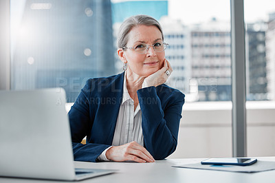 Buy stock photo Shot of a mature businesswoman sitting alone at her desk in the office