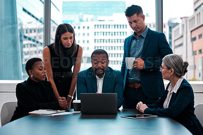 Buy stock photo Shot of a team of businesspeople gathered around a laptop in an office