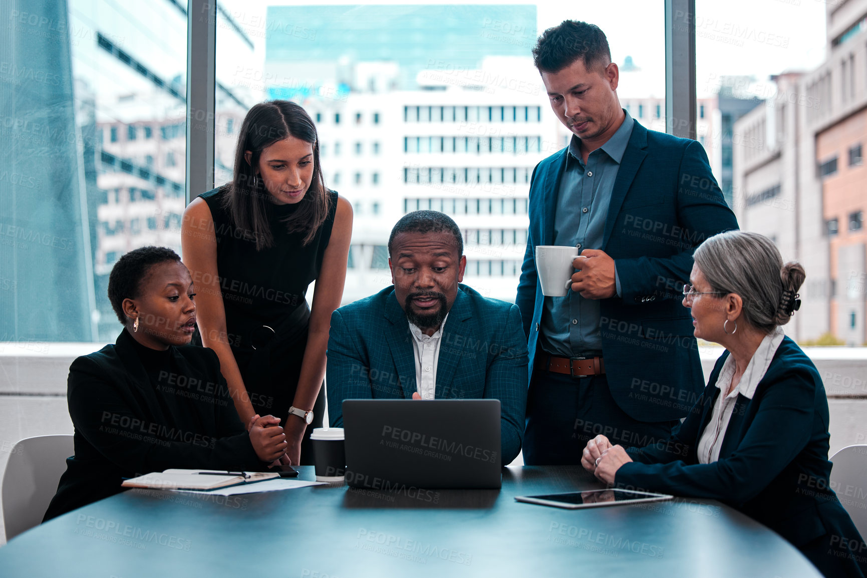 Buy stock photo Shot of a team of businesspeople gathered around a laptop in an office