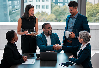 Buy stock photo Shot of coworkers shaking hands in a boardroom