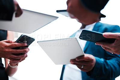 Buy stock photo Below shot of a group of unrecognizable businesspeople using their mobile devices